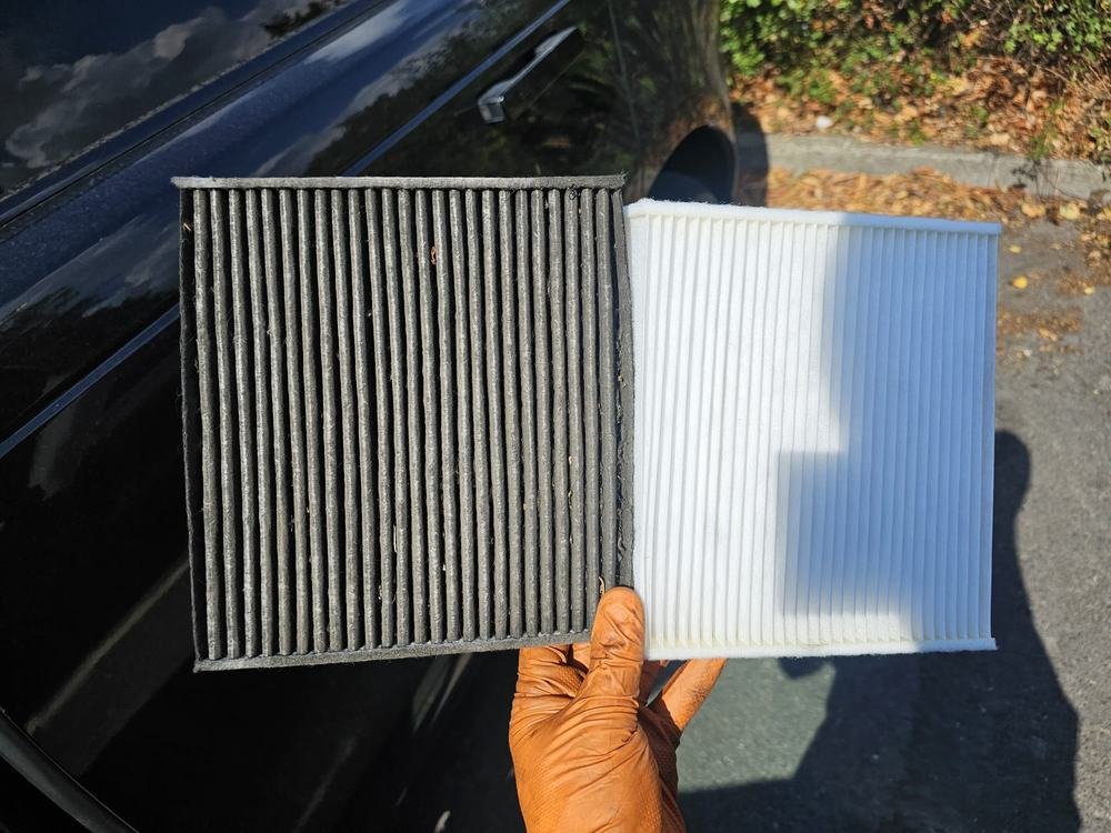 A new cabin filter held beside a used one