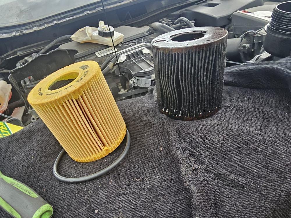 A new oil filter element beside a used one
