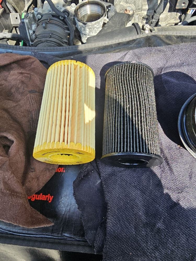 A new oil filter beside a used one